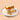 Slice of cake with whipped cream, cinnamon, and banana slices on a beige background